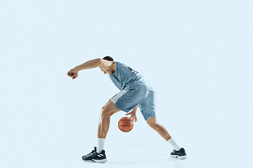 Image showing Young caucasian basketball player against white studio background