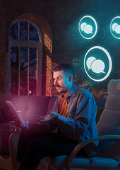 Image showing Man using gadget and receive neon notifications at home at night