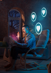 Image showing Man using gadget and receive neon notifications at home at night