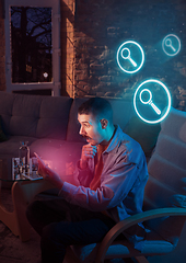 Image showing Man using gadget and receive neon notifications at home at night