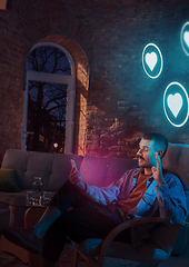 Image showing Man using gadget and receive neon notifications at home at night