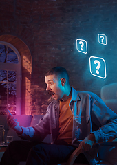 Image showing Man using gadget and receive neon notifications at home at night