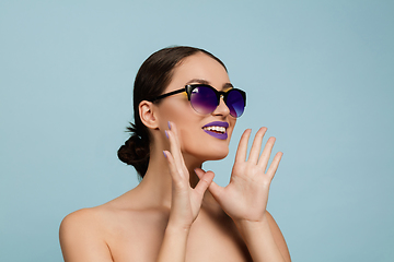 Image showing Portrait of beautiful young woman with bright make-up isolated on blue studio background