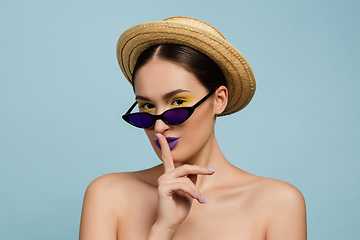 Image showing Portrait of beautiful young woman with bright make-up isolated on blue studio background