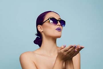 Image showing Portrait of beautiful young woman with bright make-up isolated on blue studio background