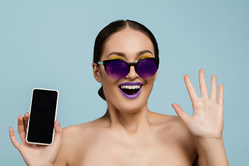 Image showing Portrait of beautiful young woman with bright make-up isolated on blue studio background