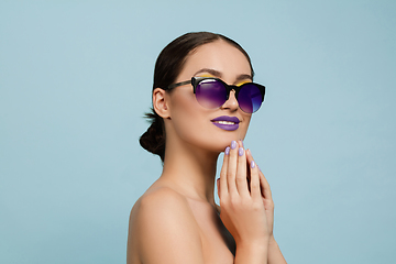 Image showing Portrait of beautiful young woman with bright make-up isolated on blue studio background