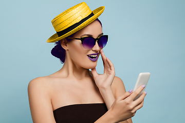 Image showing Portrait of beautiful young woman with bright make-up isolated on blue studio background