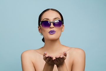 Image showing Portrait of beautiful young woman with bright make-up isolated on blue studio background