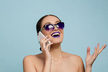 Image showing Portrait of beautiful young woman with bright make-up isolated on blue studio background