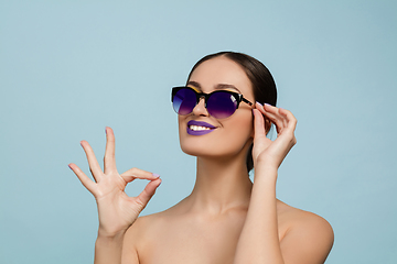 Image showing Portrait of beautiful young woman with bright make-up isolated on blue studio background