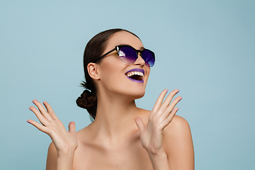 Image showing Portrait of beautiful young woman with bright make-up isolated on blue studio background