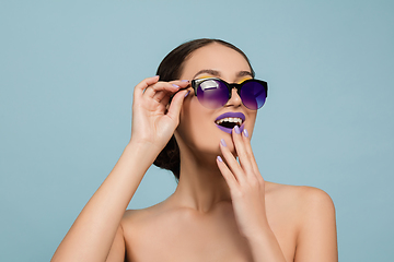 Image showing Portrait of beautiful young woman with bright make-up isolated on blue studio background