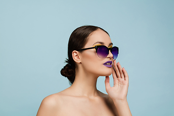 Image showing Portrait of beautiful young woman with bright make-up isolated on blue studio background