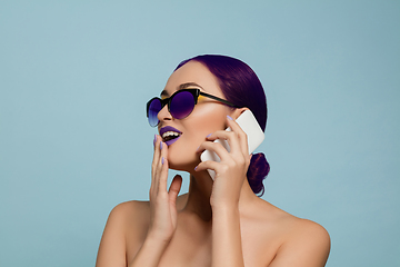 Image showing Portrait of beautiful young woman with bright make-up isolated on blue studio background