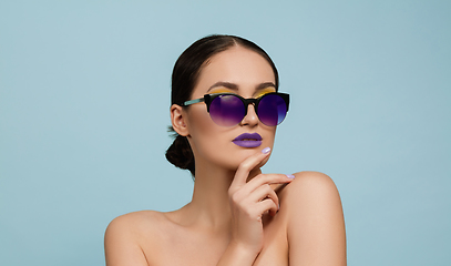 Image showing Portrait of beautiful young woman with bright make-up isolated on blue studio background