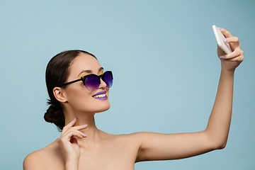 Image showing Portrait of beautiful young woman with bright make-up isolated on blue studio background