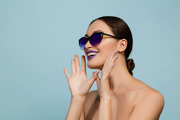 Image showing Portrait of beautiful young woman with bright make-up isolated on blue studio background