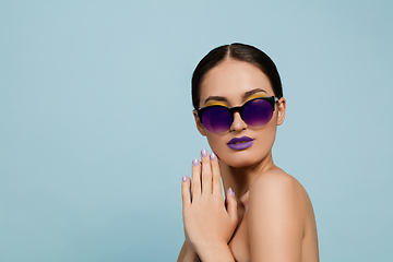 Image showing Portrait of beautiful young woman with bright make-up isolated on blue studio background