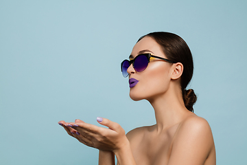 Image showing Portrait of beautiful young woman with bright make-up isolated on blue studio background