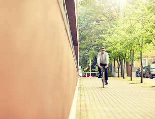 Image showing young man riding bicycle on city street