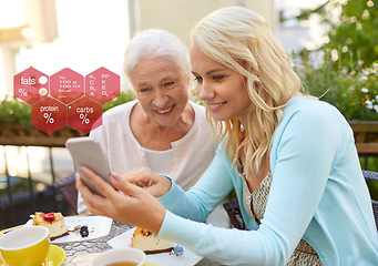 Image showing daughter and senior mother with smartphone at cafe