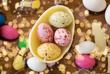 Image showing chocolate egg and candy drops on wooden table