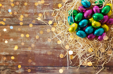 Image showing chocolate eggs in foil wrappers in straw nest