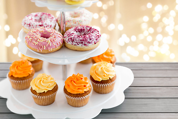 Image showing glazed donuts, cupcakes with frosting on stand