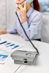 Image showing businesswoman calling on desk phone at office