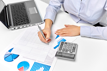 Image showing businesswoman with papers, laptop and calculator