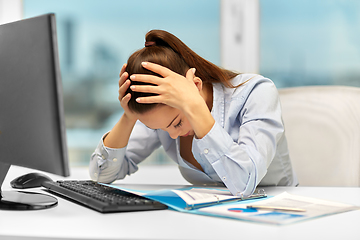 Image showing stressed businesswoman with papers at office