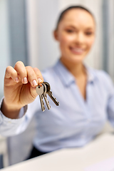 Image showing businesswoman or realtor holding keys at office