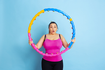 Image showing Young caucasian plus size female model\'s training on blue background