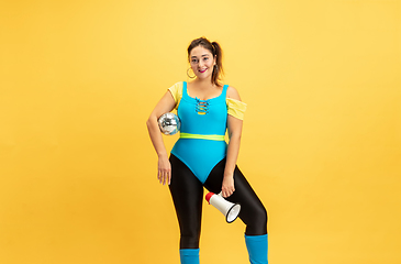 Image showing Young caucasian plus size female model\'s training on yellow background