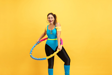 Image showing Young caucasian plus size female model\'s training on yellow background