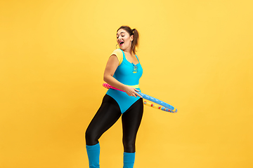 Image showing Young caucasian plus size female model\'s training on yellow background