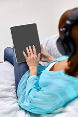 Image showing woman with tablet pc and headphones at home