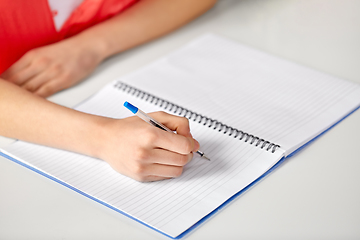 Image showing hands of student girl with pen writing to notebook