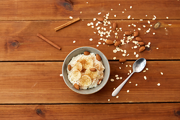 Image showing oatmeal with banana and almond on wooden table