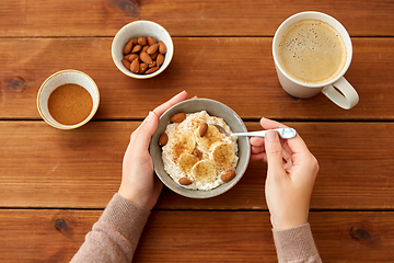 Image showing hands with oatmeal breakfast and cup of coffee