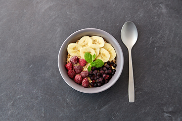 Image showing oatmeal breakfast with berries, banana and spoon