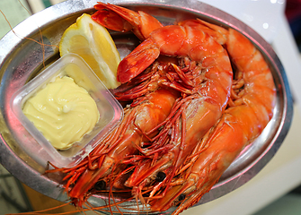 Image showing Jumbo shrimps with lemon and sauce on metal plate