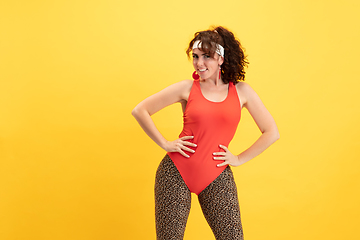 Image showing Young caucasian plus size female model\'s training on yellow background