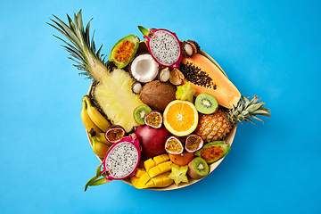 Image showing plate of exotic fruits on blue background