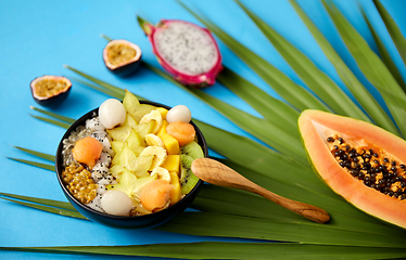 Image showing mix of exotic fruits in bowl with wooden spoon