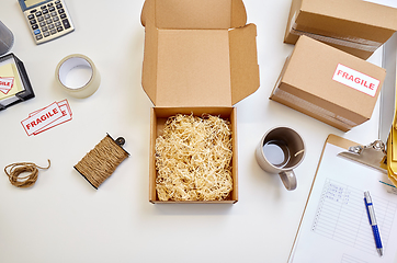 Image showing parcel with straw filler and mug at post office