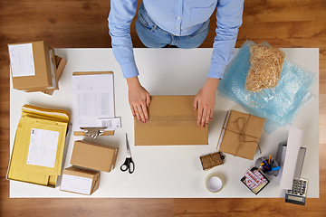 Image showing woman packing parcel box with adhesive tape