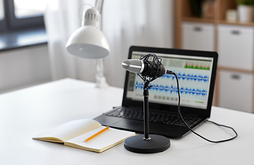 Image showing microphone, laptop and notebook on table