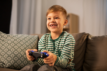 Image showing little boy with gamepad playing video game at home